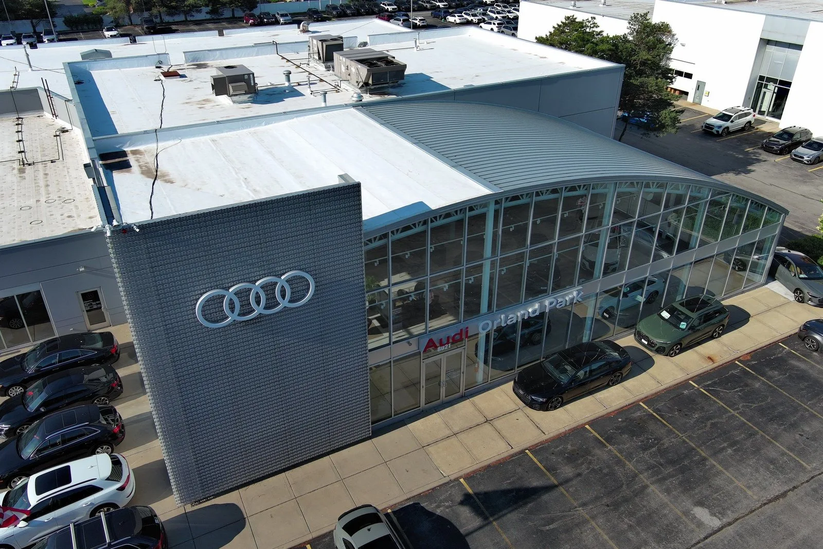 Front-left drone elevation of Audi Orland Park dealership after mod-bit roof recover by Americanstruction