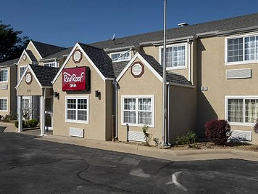 Front elevation of suburban franchise hotel with shingle roof, dormers, and entrance canopy