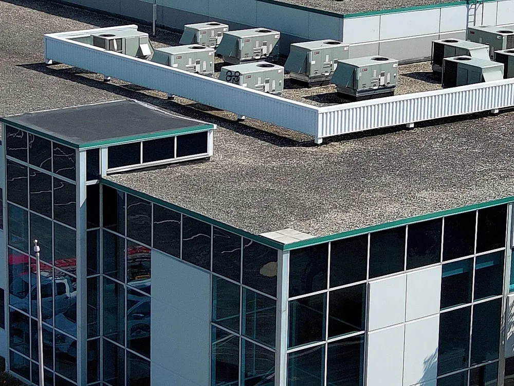 Drone view of modern mid-rise office building with glass facade and flat roof