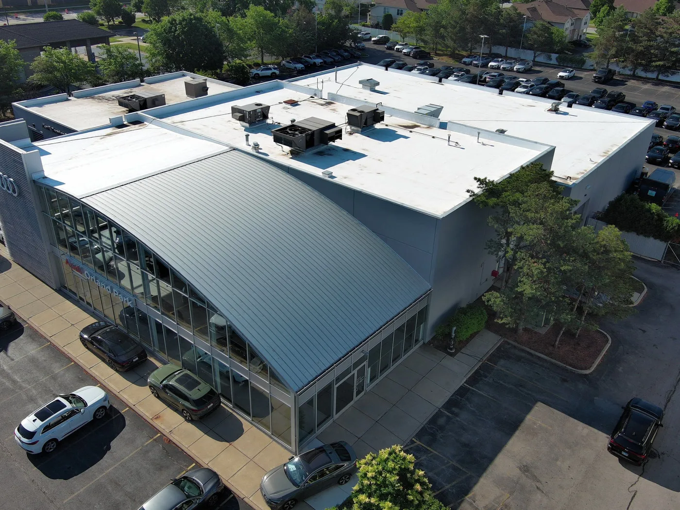 Completed mod-bit roof recover on Audi Orland Park dealership, front-right drone elevation