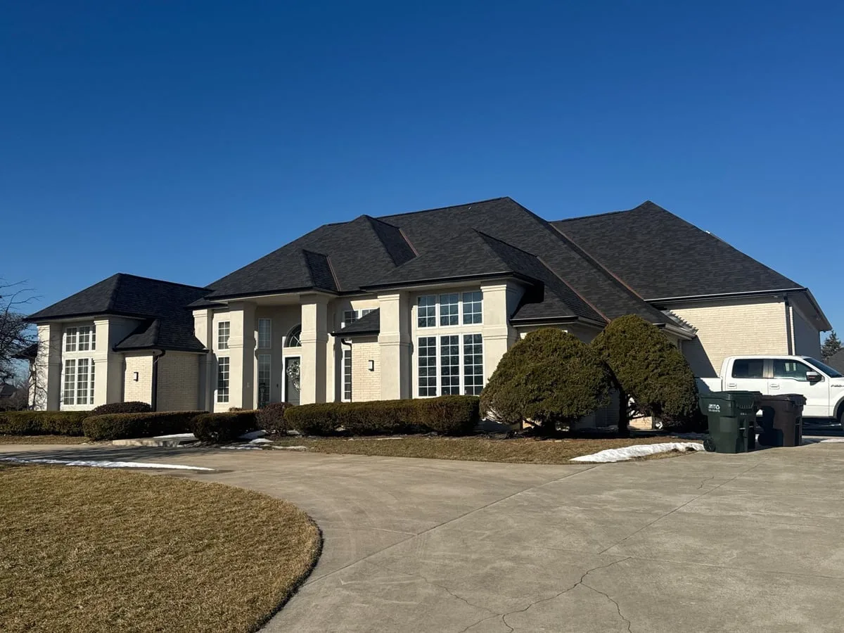 Fatima Callahan's Monee home with Onyx Black shingle, copper valley metal, black seamless gutters, and 13 solar venting skylights
