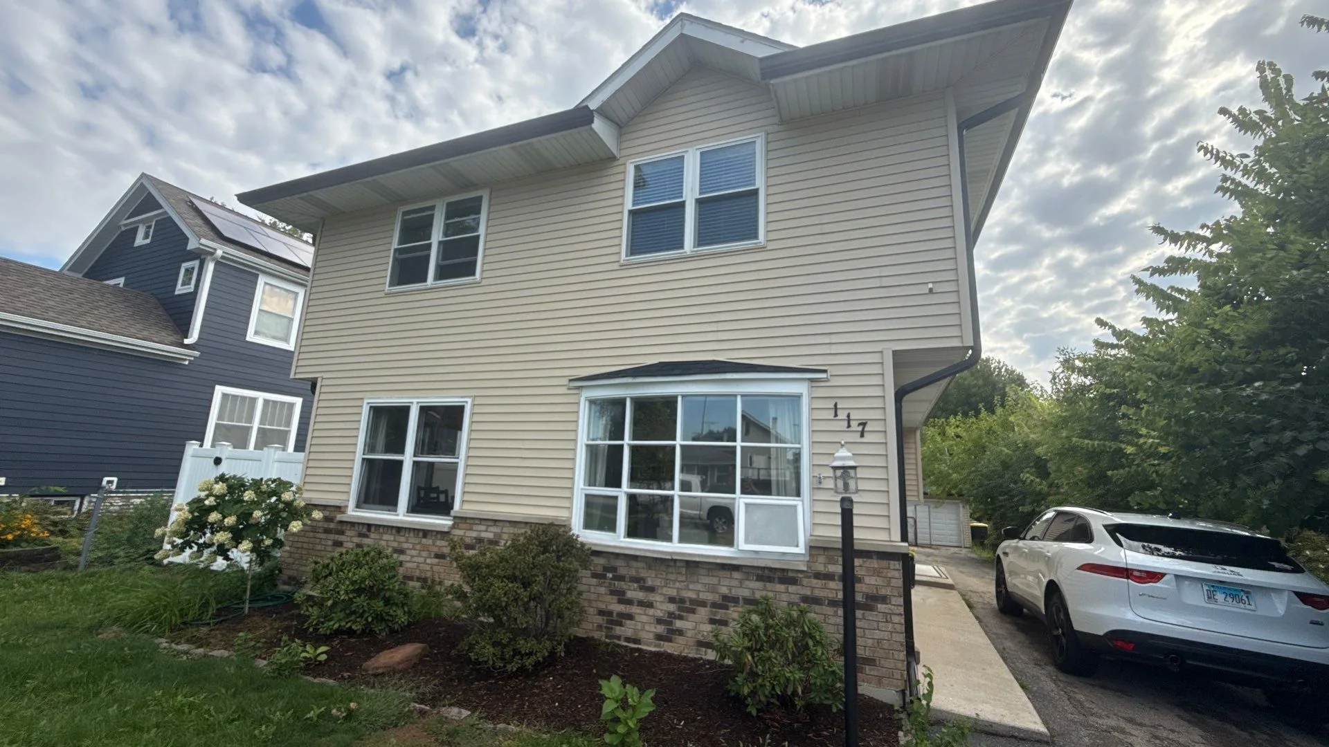 Westmont home with faded tan siding and older windows before the Americanstruction exterior project