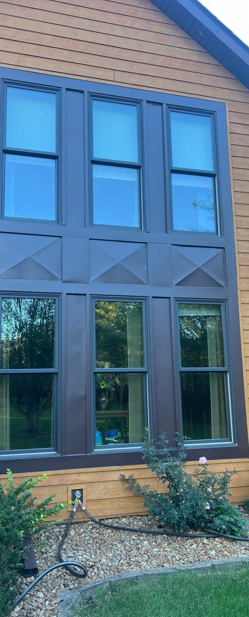 Two-story dark-framed window assembly installed by Americanstruction